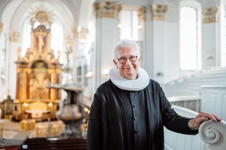 Hauptpastor Alexander Roeder im Talar in der Kirche