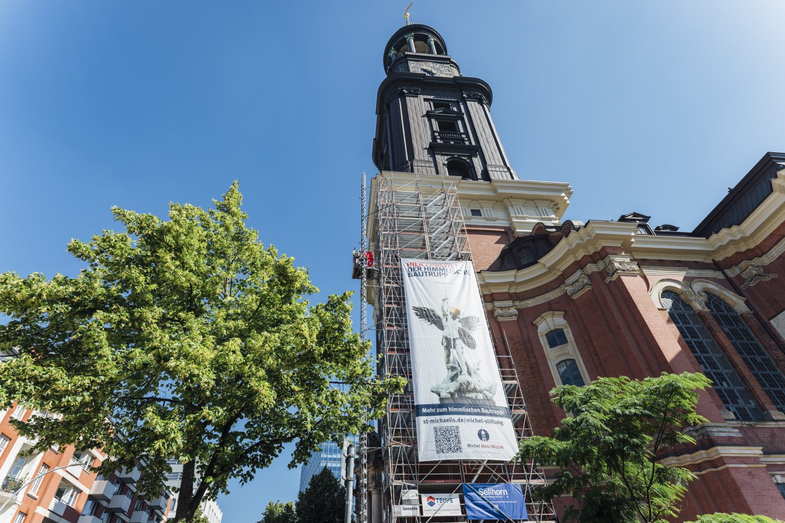 An der Südseite des Michel-Turms ist ein 33 Meter hohes Gerüst mit Banner aufgebaut