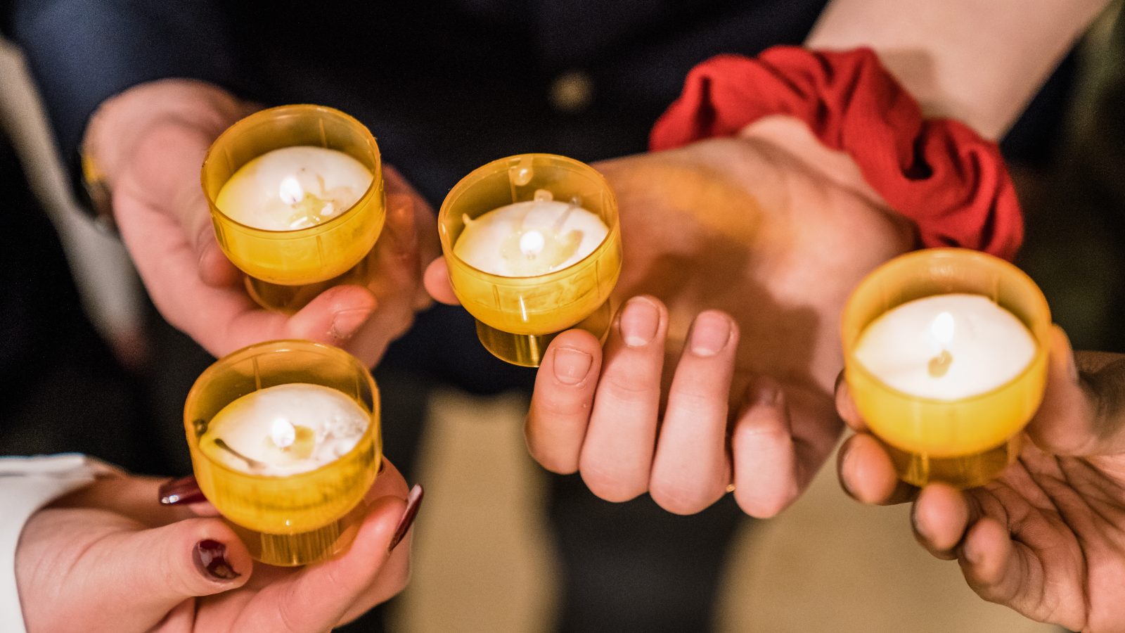 Hände, die Kerzenlichter halten