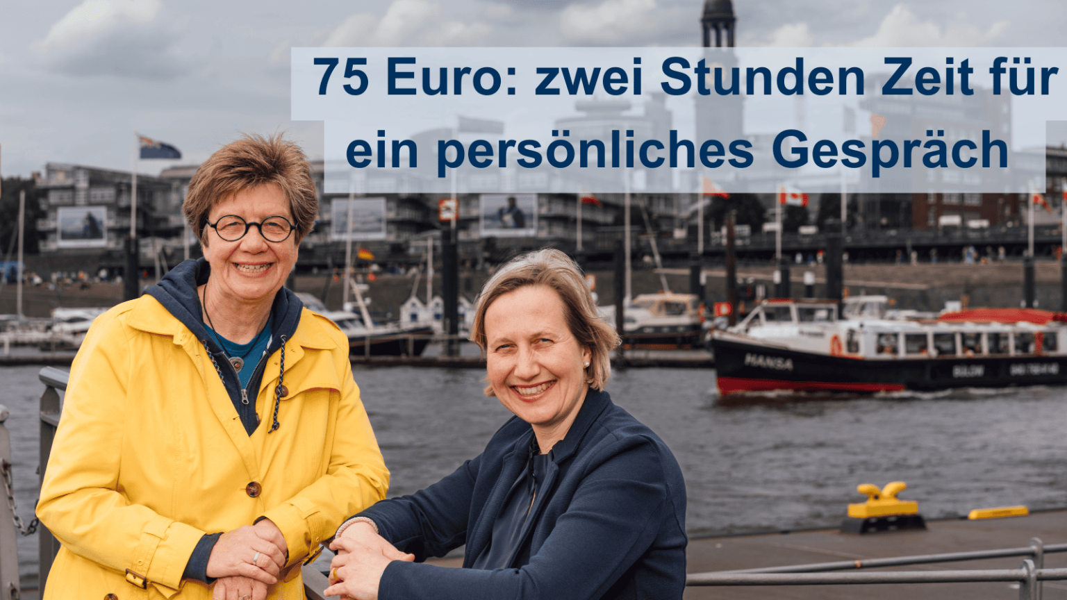 Diakonin Anke Frickmann und Pastorin Corinna Senf stehen am Hamburger Hafen, hinter ihnen ist der Michel-Kirchturm zu sehen