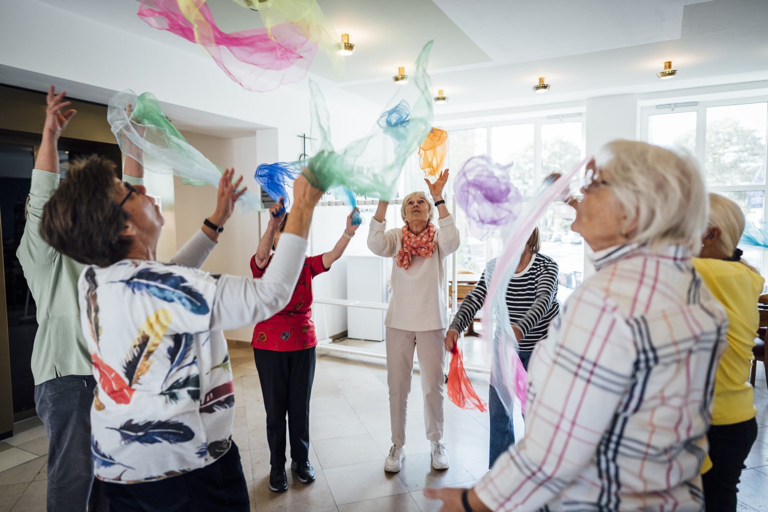 Eine Gruppe Frauen wirft bunte Tücher in die Luft