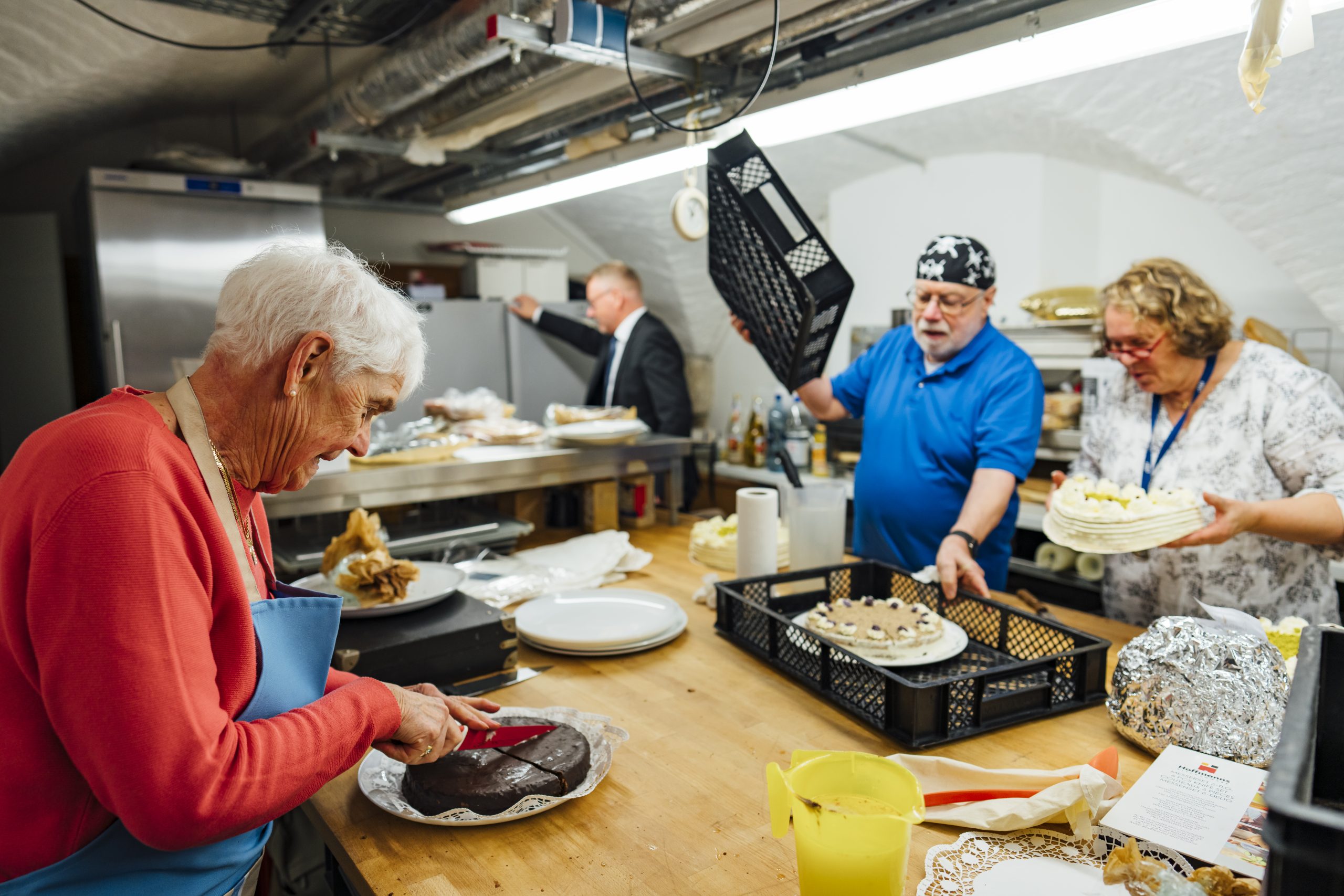 Drei Ehrenamtliche bereiten die Kuchen für die Sitftungsversammlung der Stiftung St. Michaelis vor.