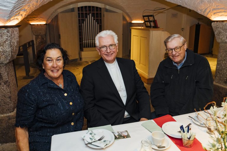 Herr Röder sitzt mit zwei Stiftern am Tisch in der Krypta.
