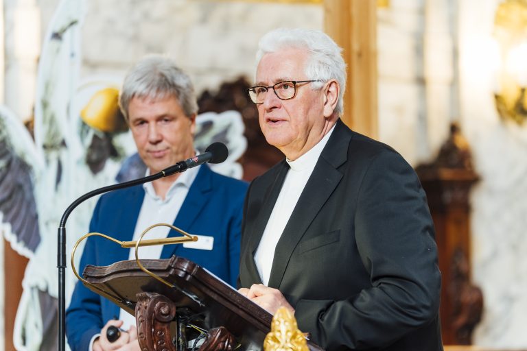 Hauptpastor Alexander Röder hält eine Rede zur Stiftungsversammlung. Im Hintergrund steht Herr Kutz.